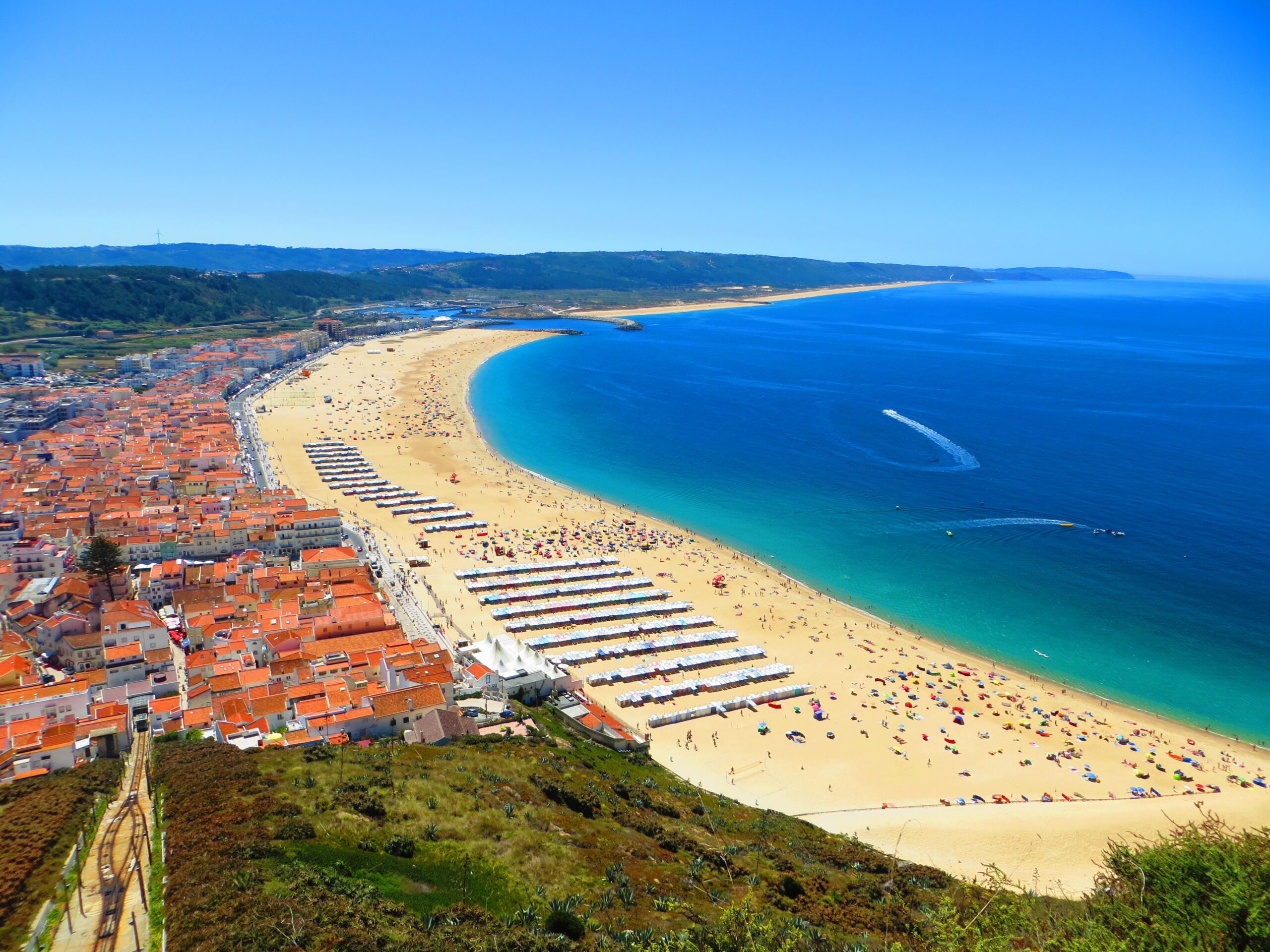 Nazaré cliffs and fishing village in Portugal, famous for the Nazaré Canyon and record-breaking giant waves, featured in the Fátima, Batalha, Nazaré & Óbidos Private Day Tour by Lux Motion.